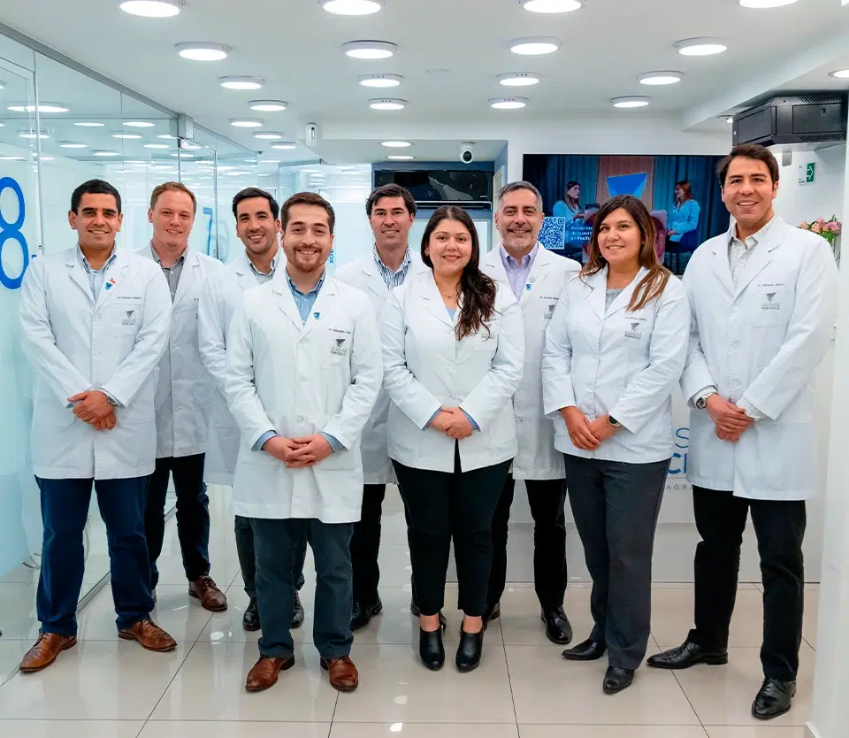 Equipo de odontólogos de Dentistas por Chile, con delantal blanco, de pie en la clínica