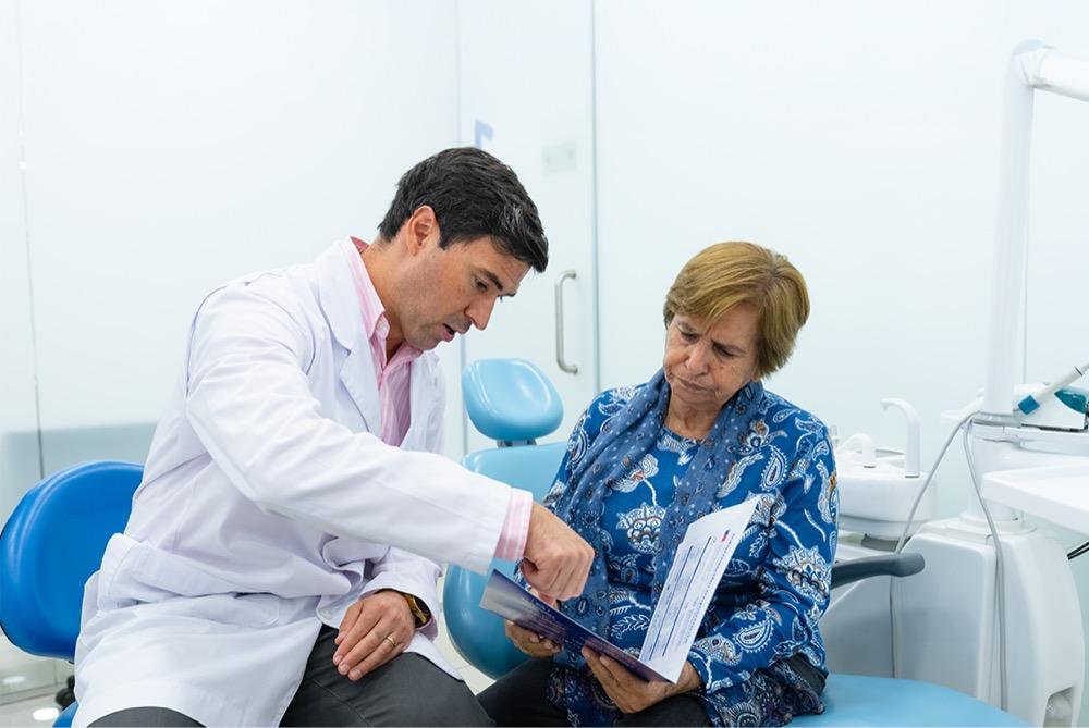 Dentista explicando el presupuesto del tratamiento a una paciente en la clínica
