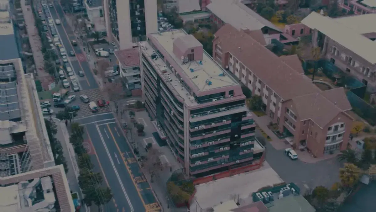 Vista aérea del edificio de la clínica en Av. Salvador, Providencia, con la avenida y su pista de buses en primer plano
